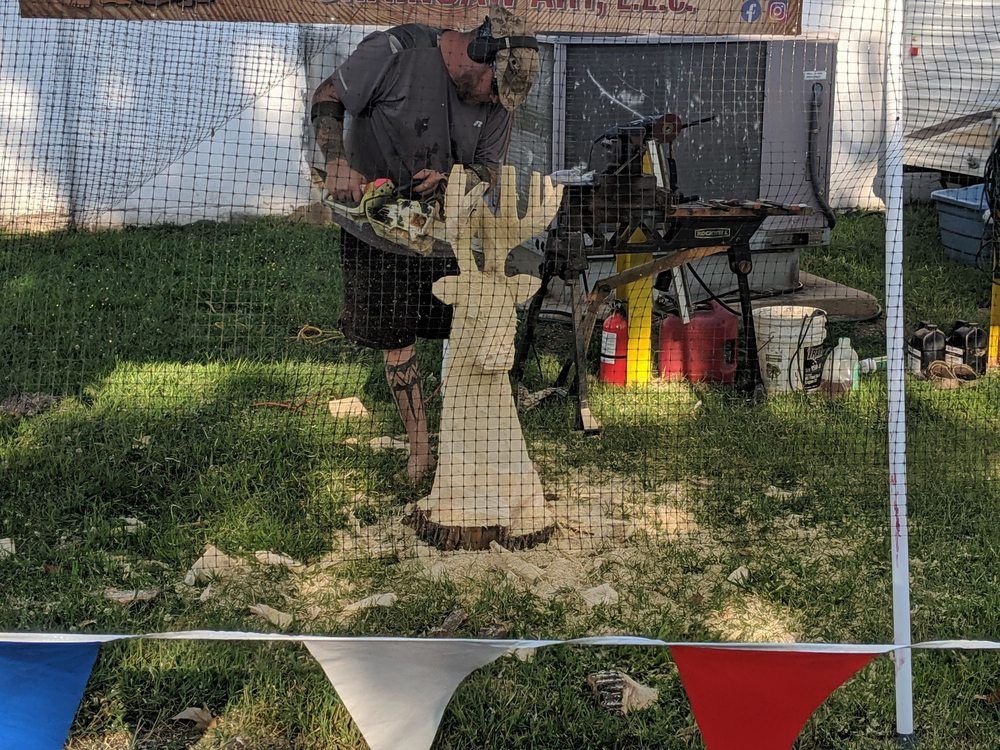 A man is carving a deer head out of wood.