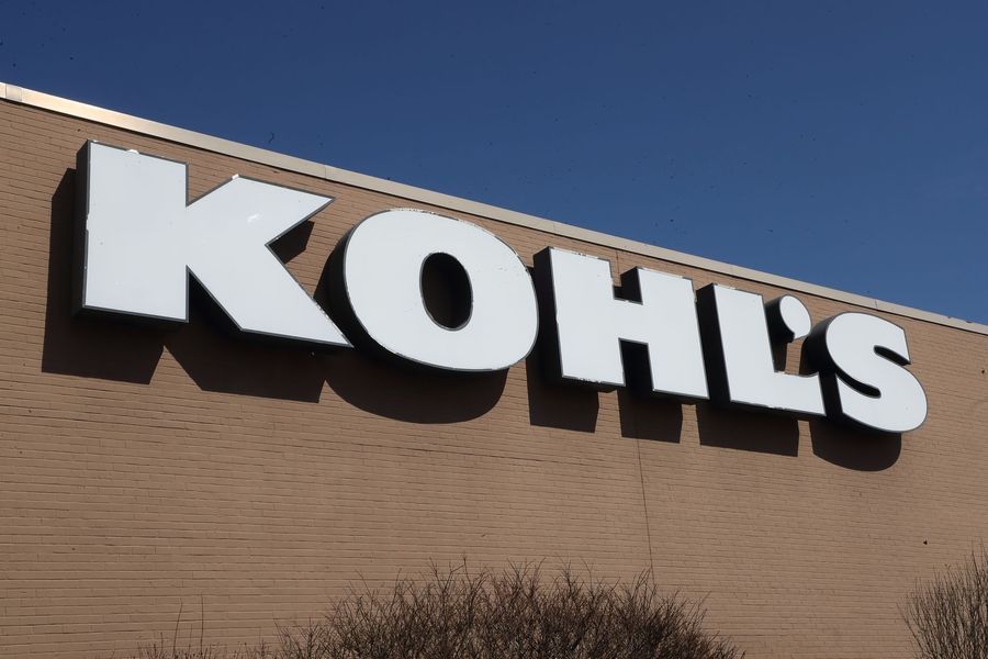 Kohl's store sign on a brick building against a clear blue sky.