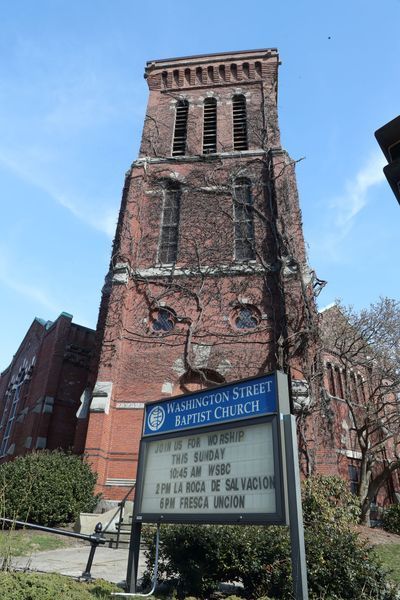 Washington Street Baptist Church with a sign, brick tower, and green ivy.