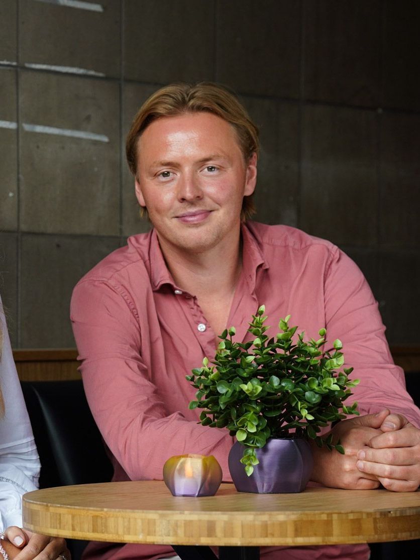 Simon Bentsen sitter ved et bord.