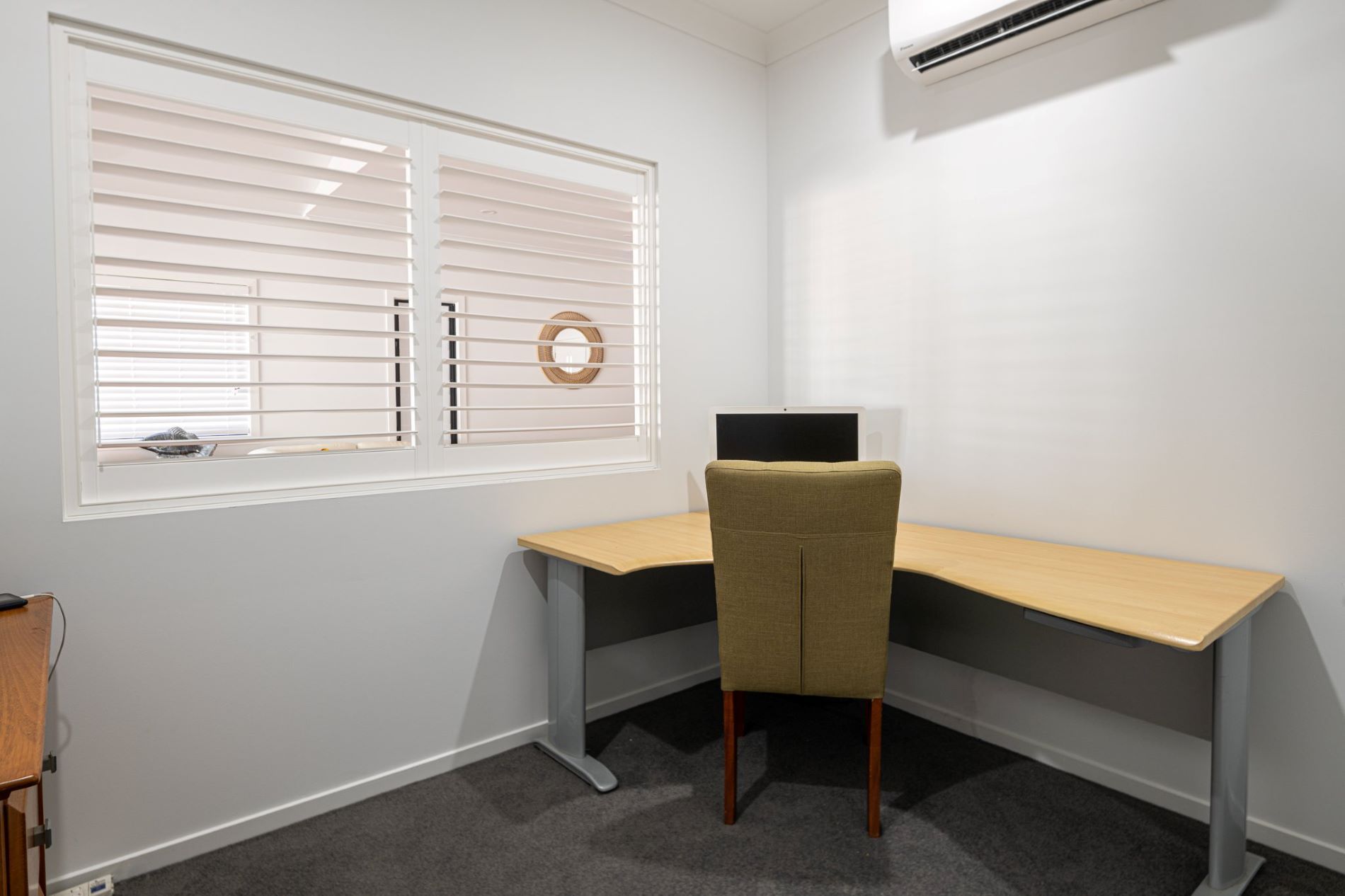 A Small Office With a Desk and Chair in Front of a Window — Wilkinson Homes in Annandale, QLD