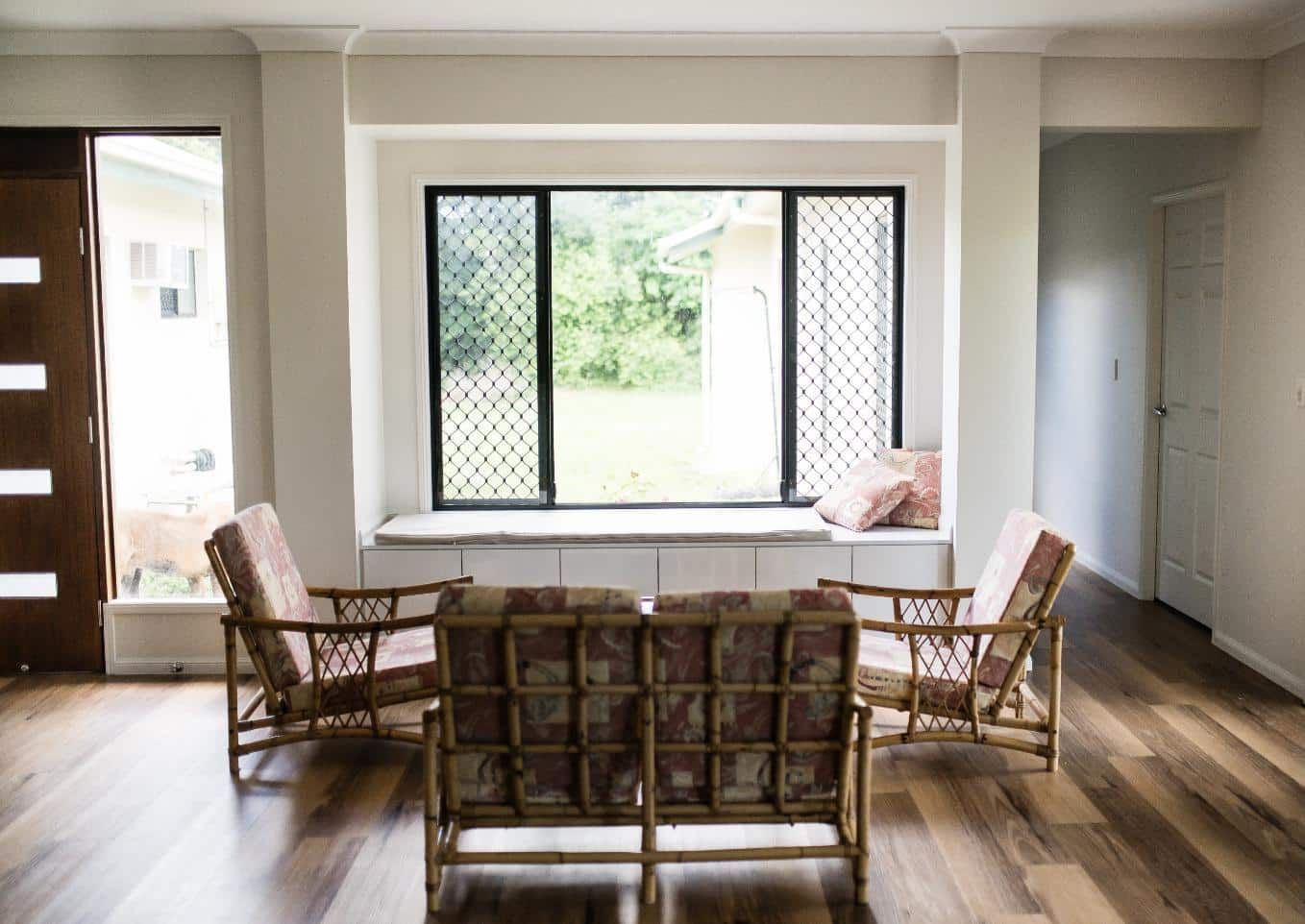 A Living Room With a Couch and Chairs in Front of a Window — Wilkinson Homes in Annandale, QLD