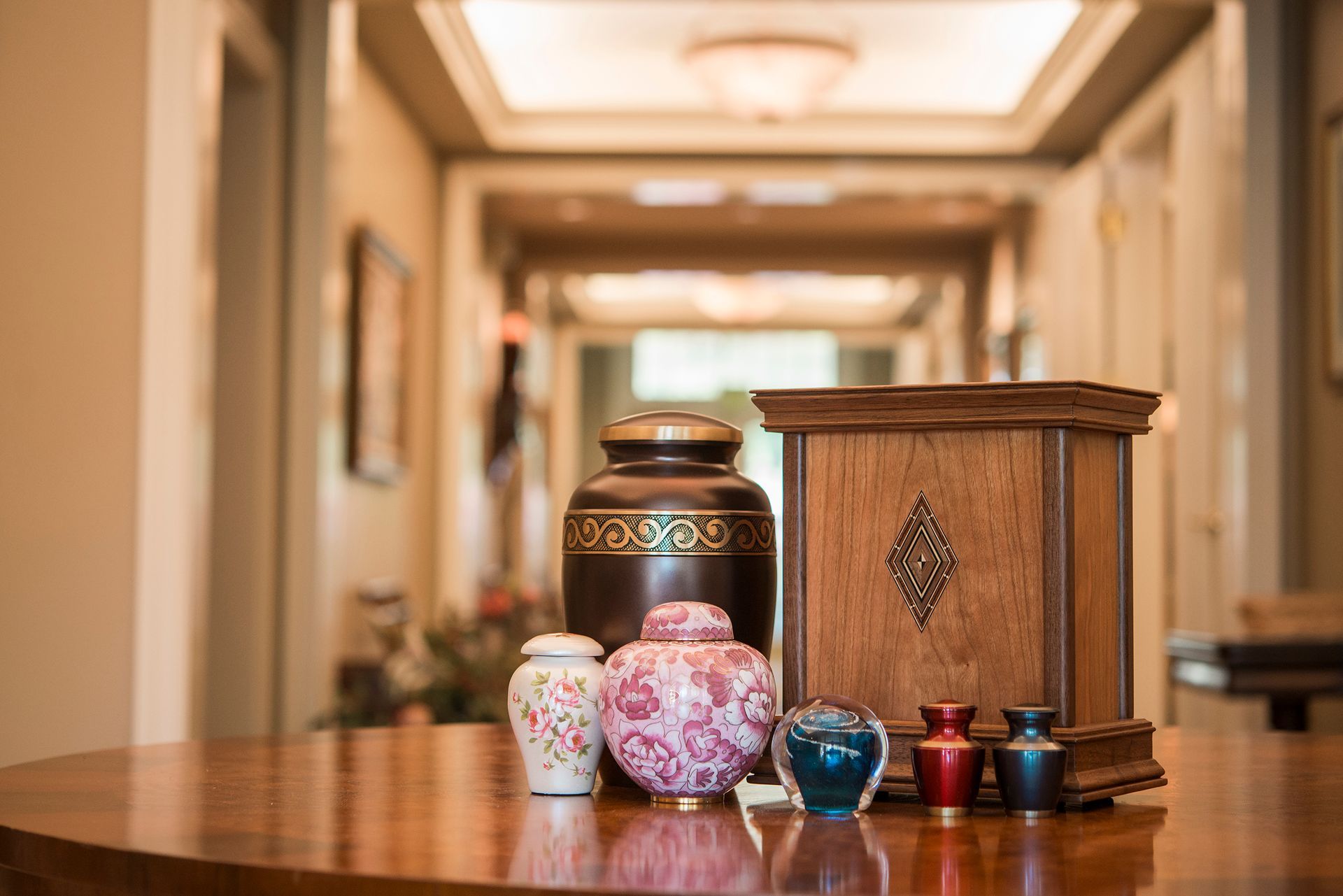 A group of urns sitting on top of a wooden table.