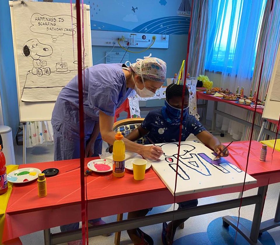 Dr Beelke D'hondt, a paediatric surgeon who practises at Netcare Christiaan Barnard Memorial Hospital, assists Lesedi Mogotlhe with the mural