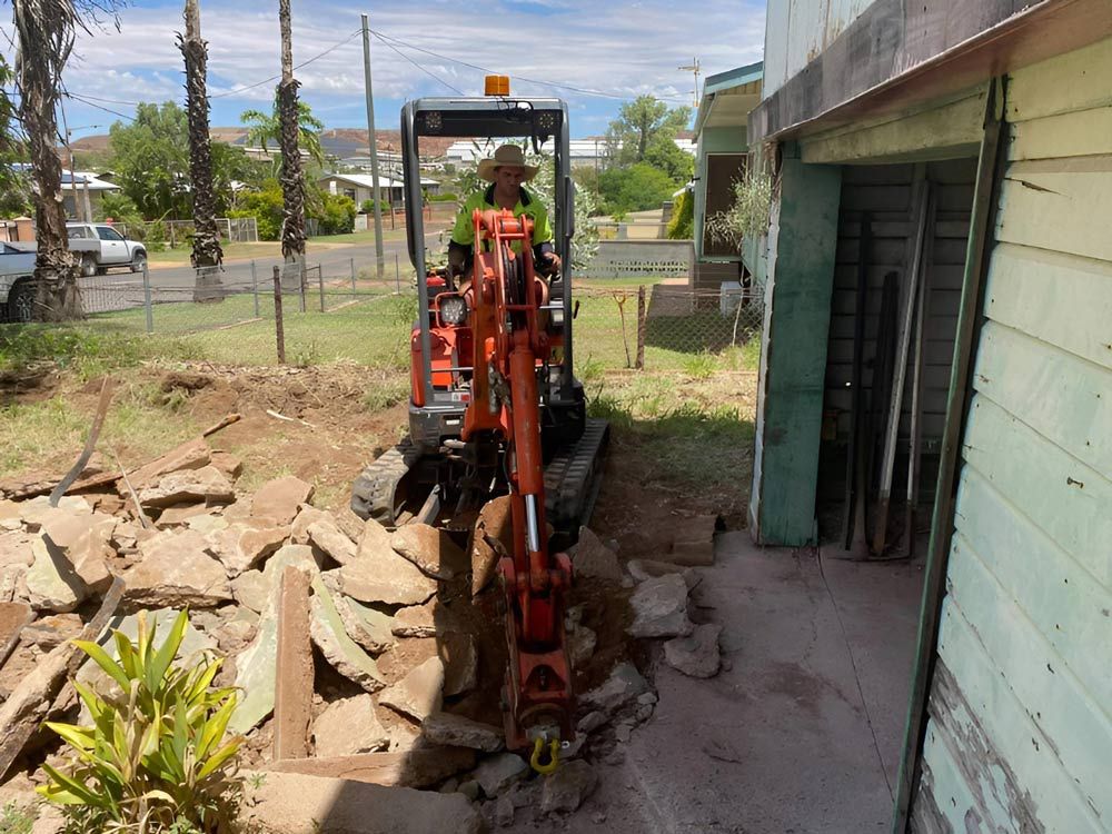 The Man Is Destroying The Concrete Slab Using The Excavator — NQES Industries in Blackall-Tambo, QLD