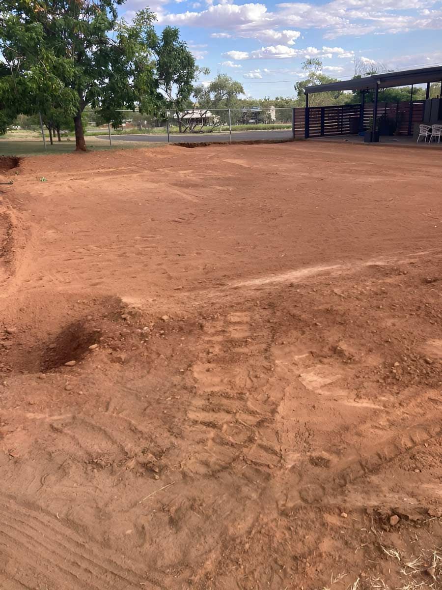 A Dirt Field Is Enclosed By A Fence, With Trees Visible In The Background — NQES Industries in Ryan, QLD