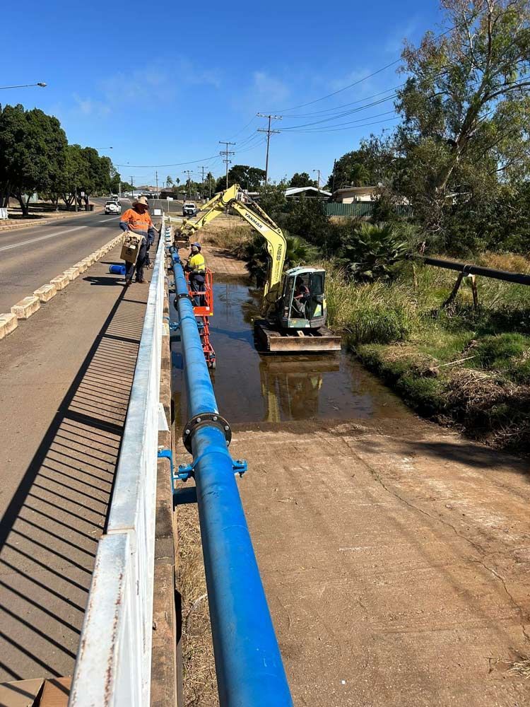 Installing Water Pipe In The Bridge — NQES Industries in Cloncurry, QLD