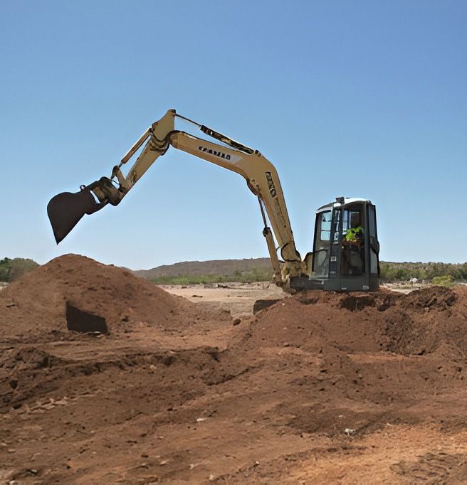 A Yellow Excavator Is Heaping Soil Into A Pile — NQES Industries in Cloncurry, QLD