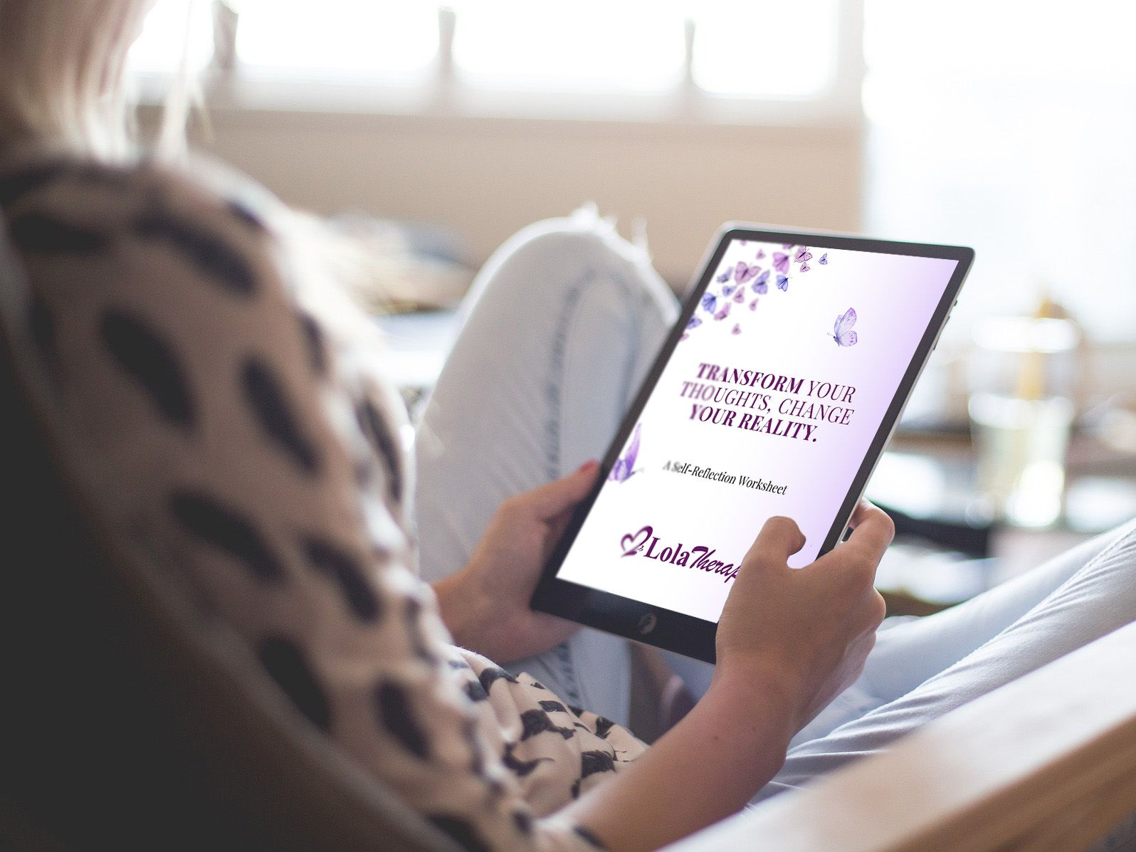 A woman is sitting at a desk using a laptop computer.