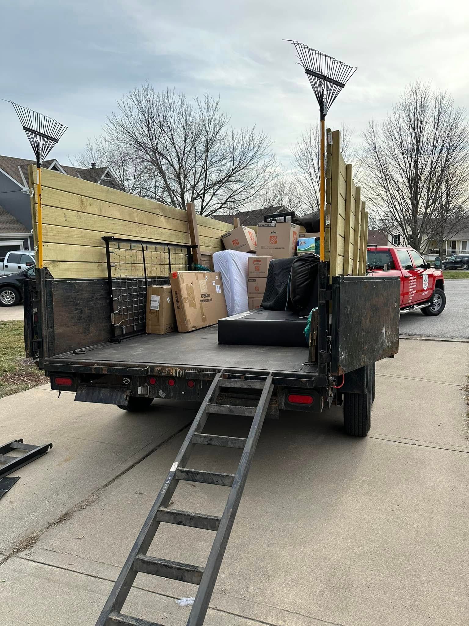 Yellow zero-turn mower on green grass in a field with trees under a blue sky.