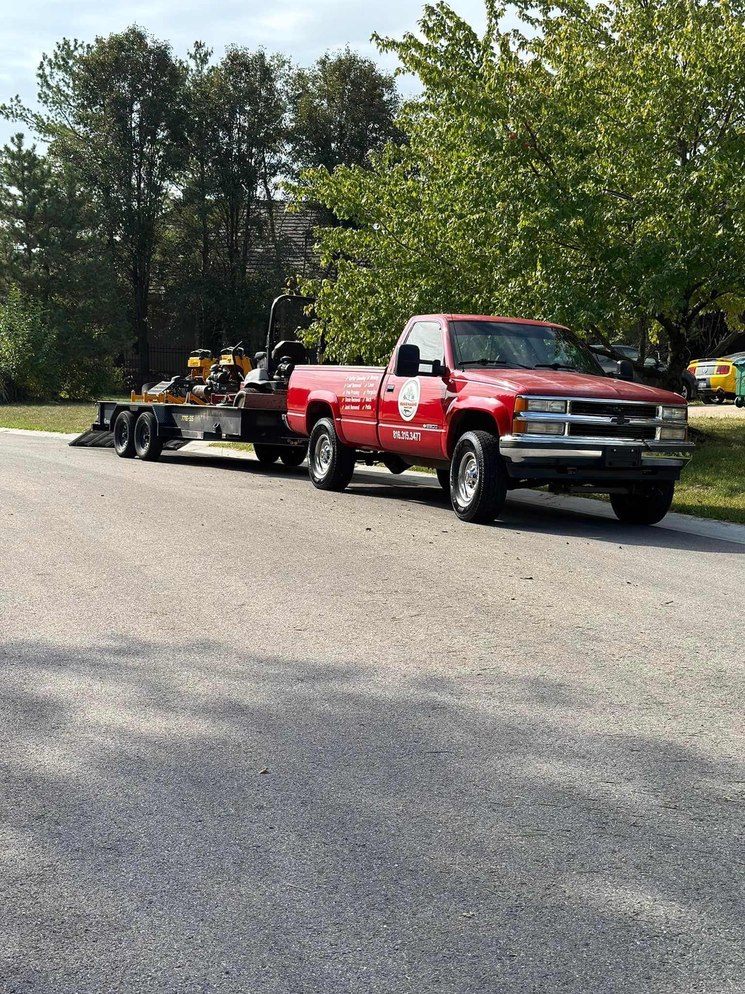 Yellow zero-turn mower on green grass in a field with trees under a blue sky.