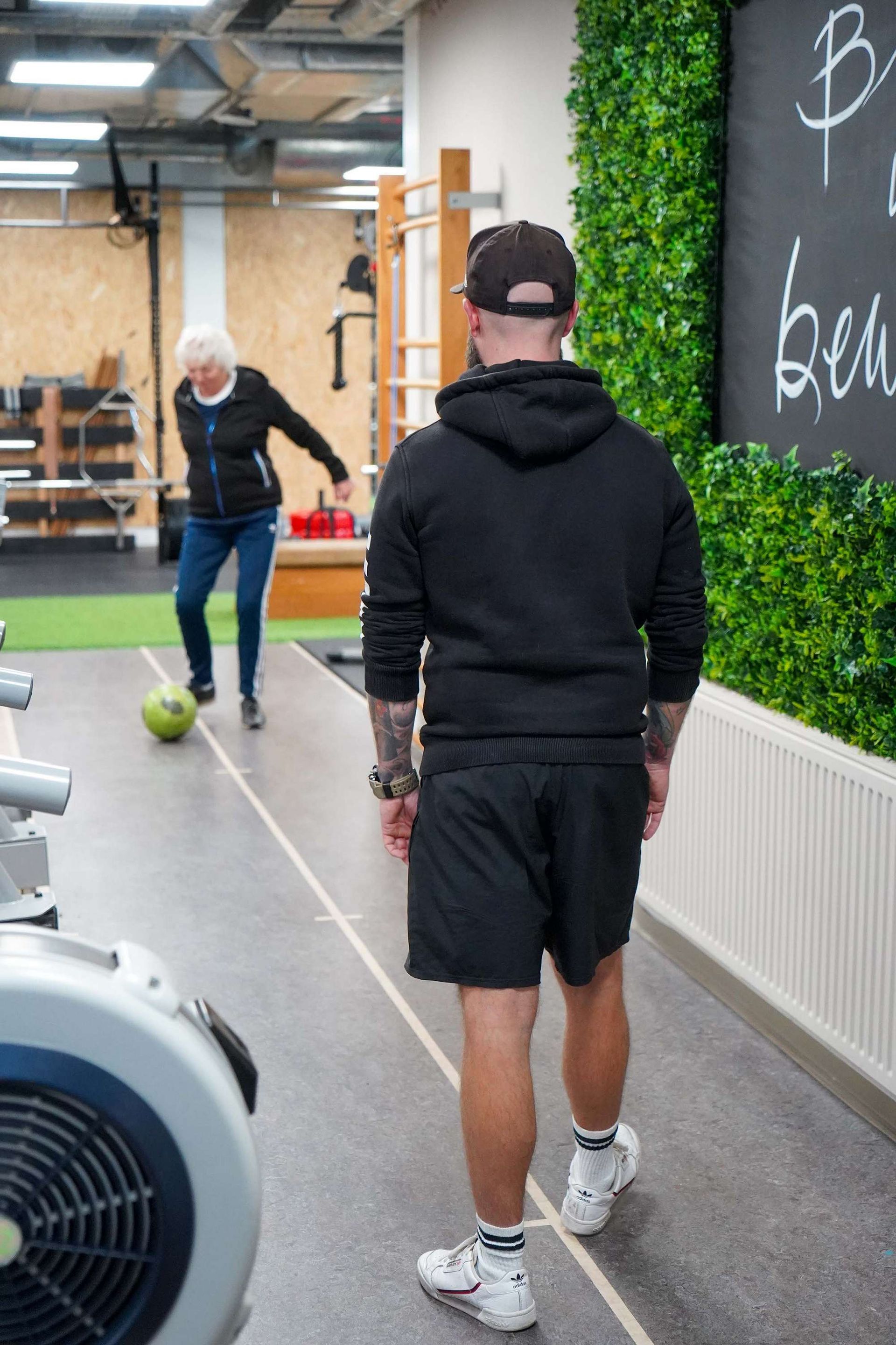 Een man en een vrouw spelen voetbal in een gymzaal.