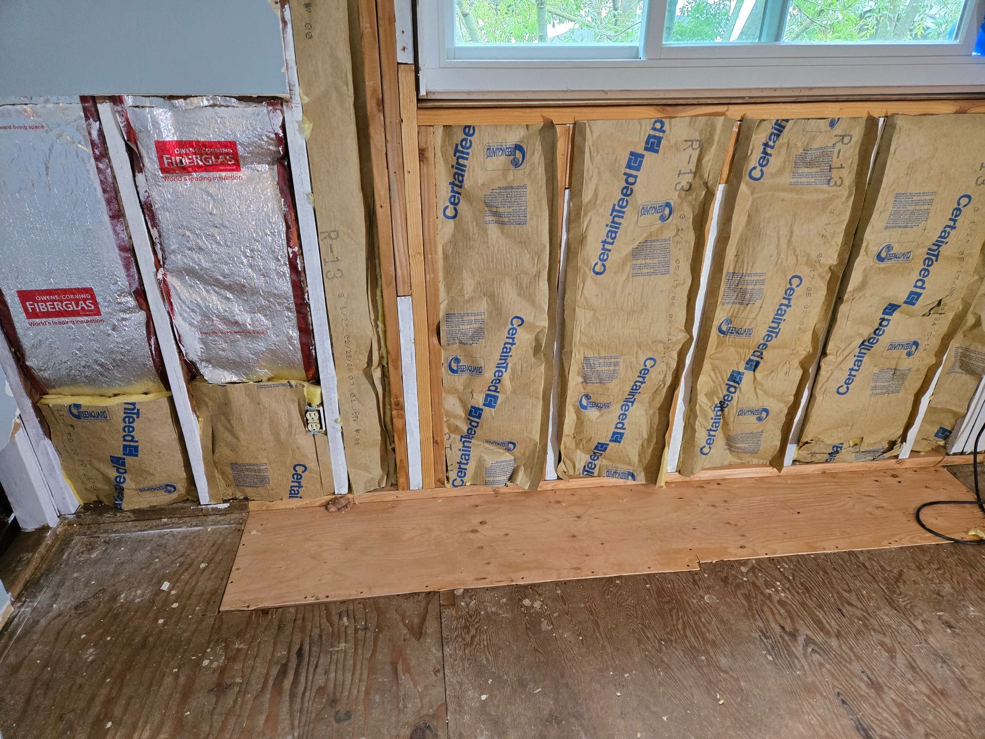Interior wall under construction with insulation and wood framing.