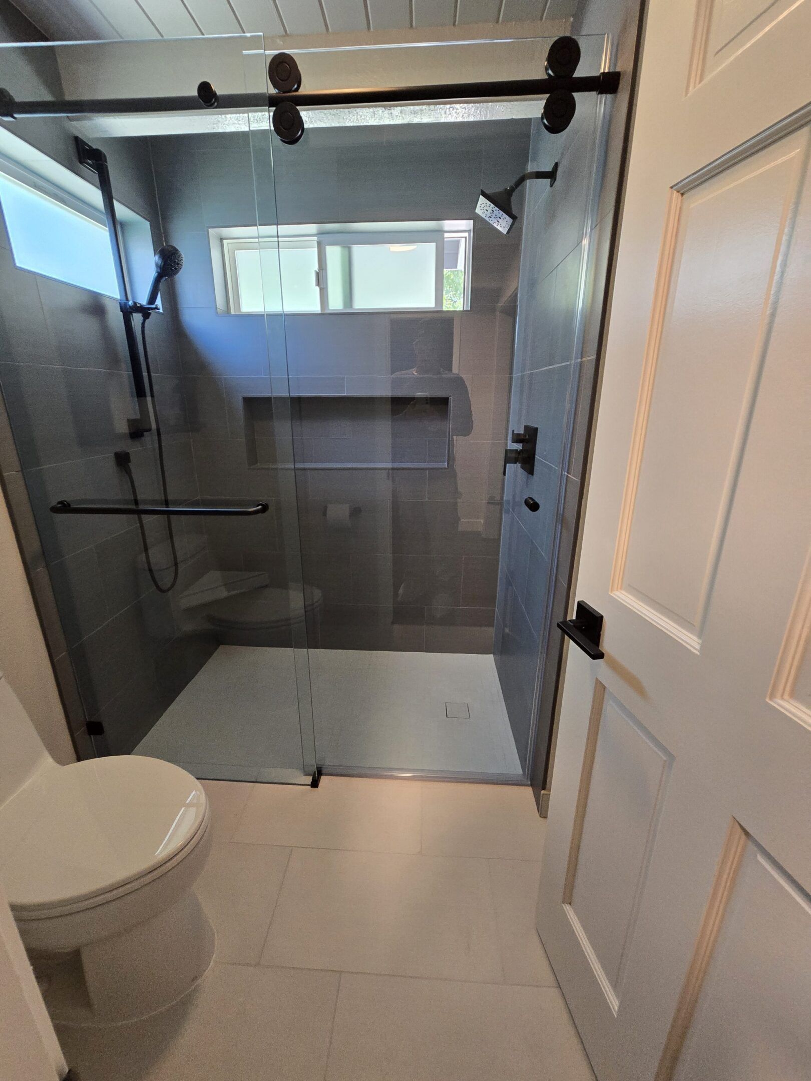 Bathroom with a glass shower enclosure and a toilet.