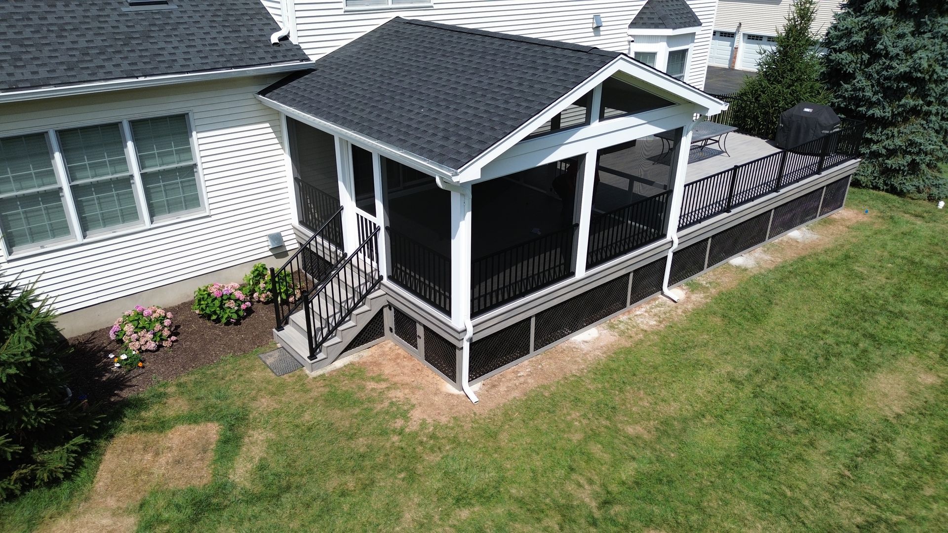 Covered porch and deck with black railing installed by New Dimensions NJ deck builders