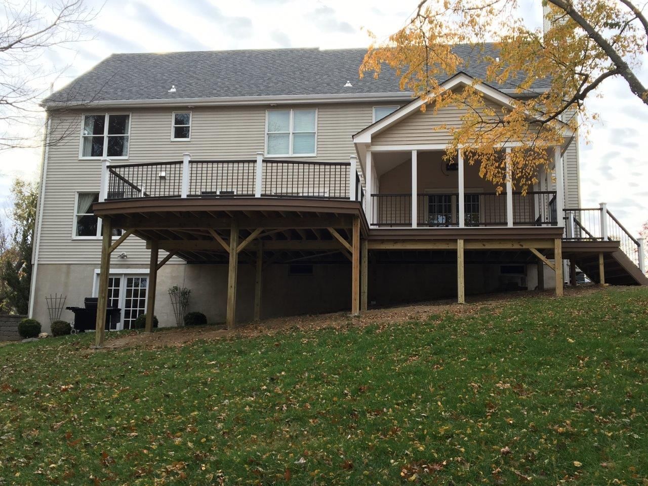 A large house with a large deck on the back of it