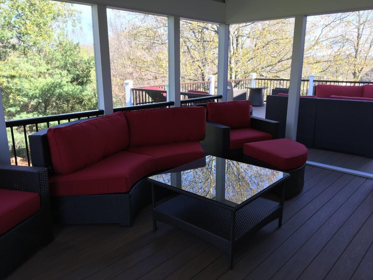 A screened in porch with a couch and chairs