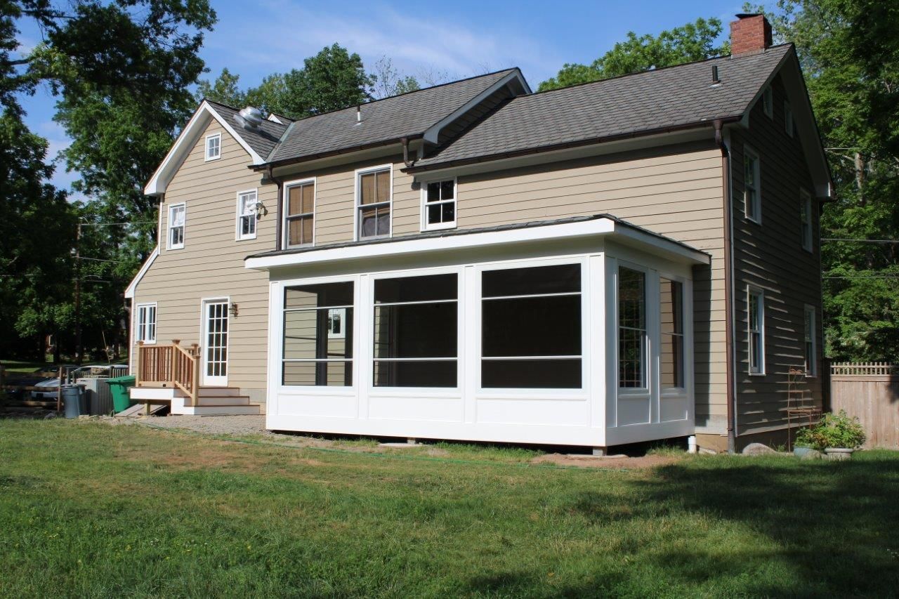A house with a screened in porch in front of it