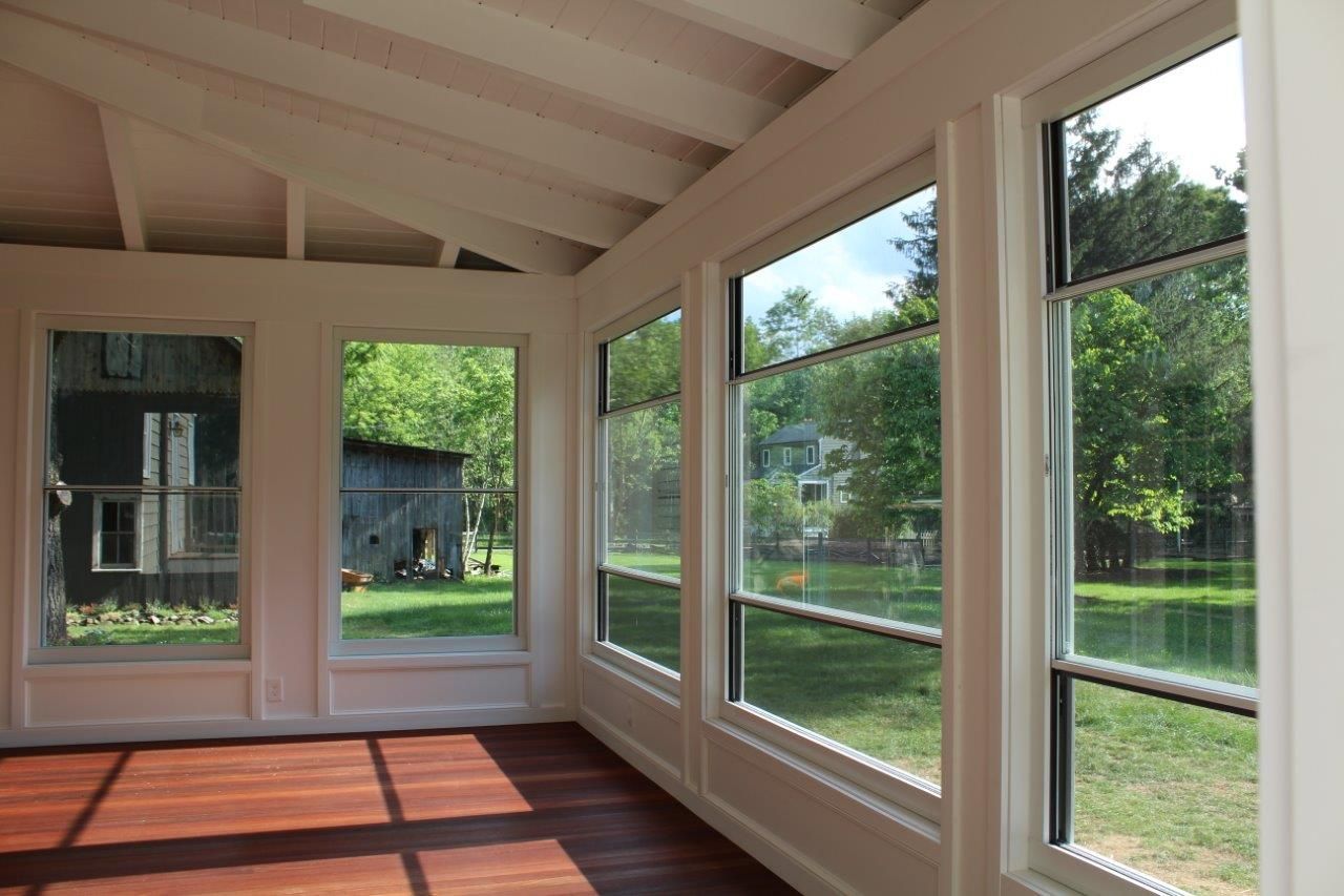 A room with lots of windows and a wooden floor