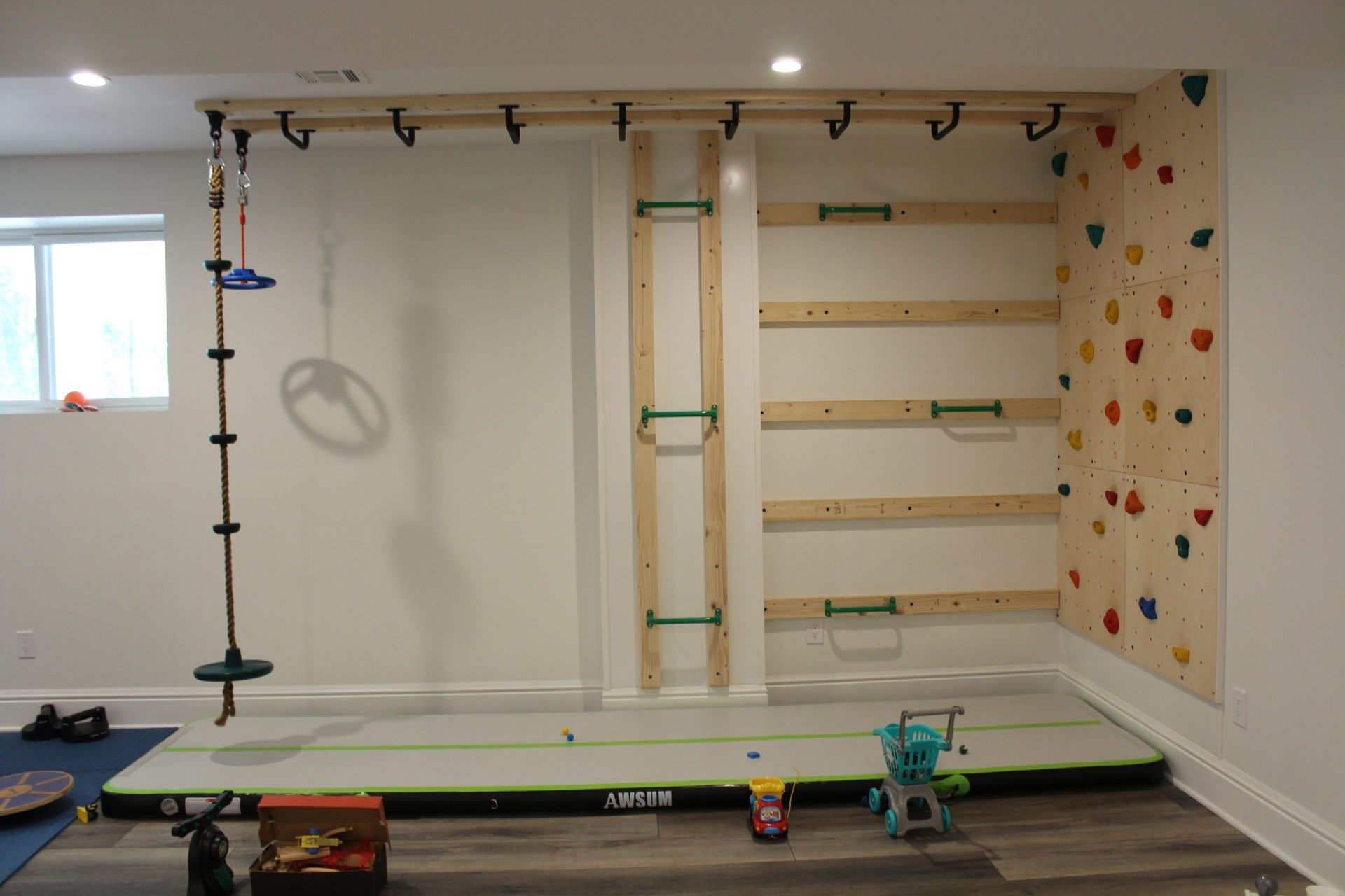 There is a climbing wall in the corner of the room.