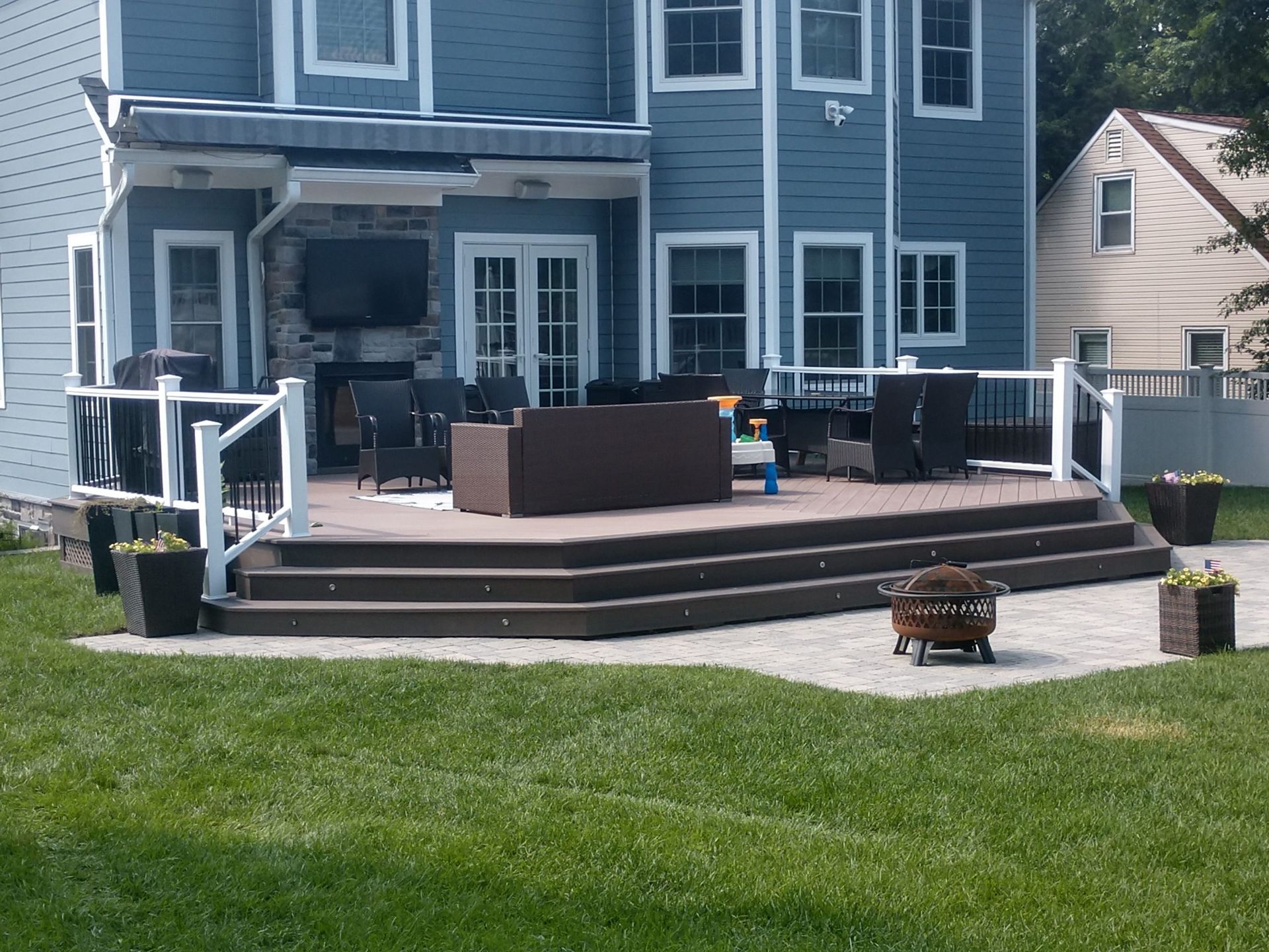 Low-profile composite deck with wide steps, white railings, and outdoor furniture.