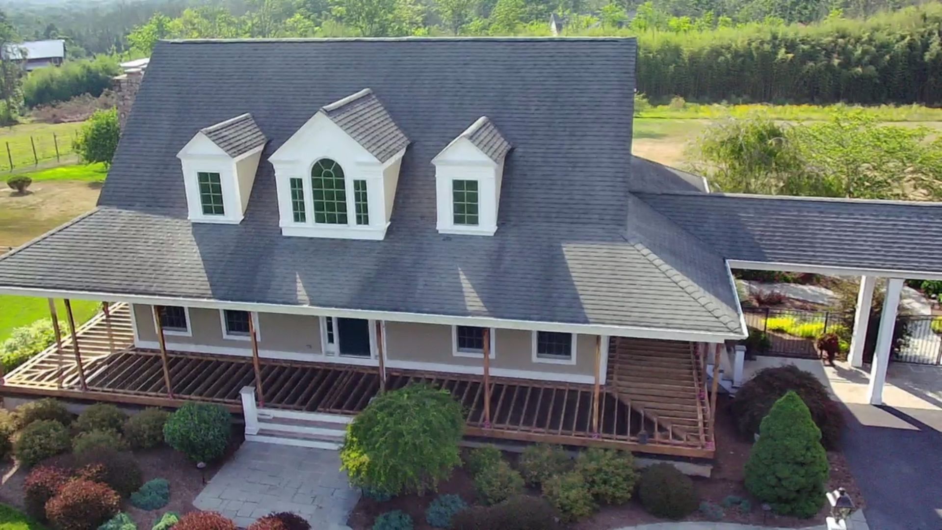 Beige house with elevated white-railed deck and composite flooring, overlooking lawn