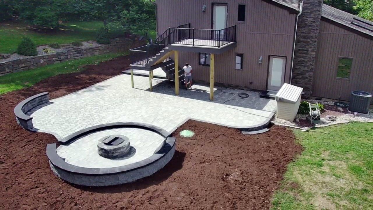 An aerial view of a patio with a fire pit in the middle of it.