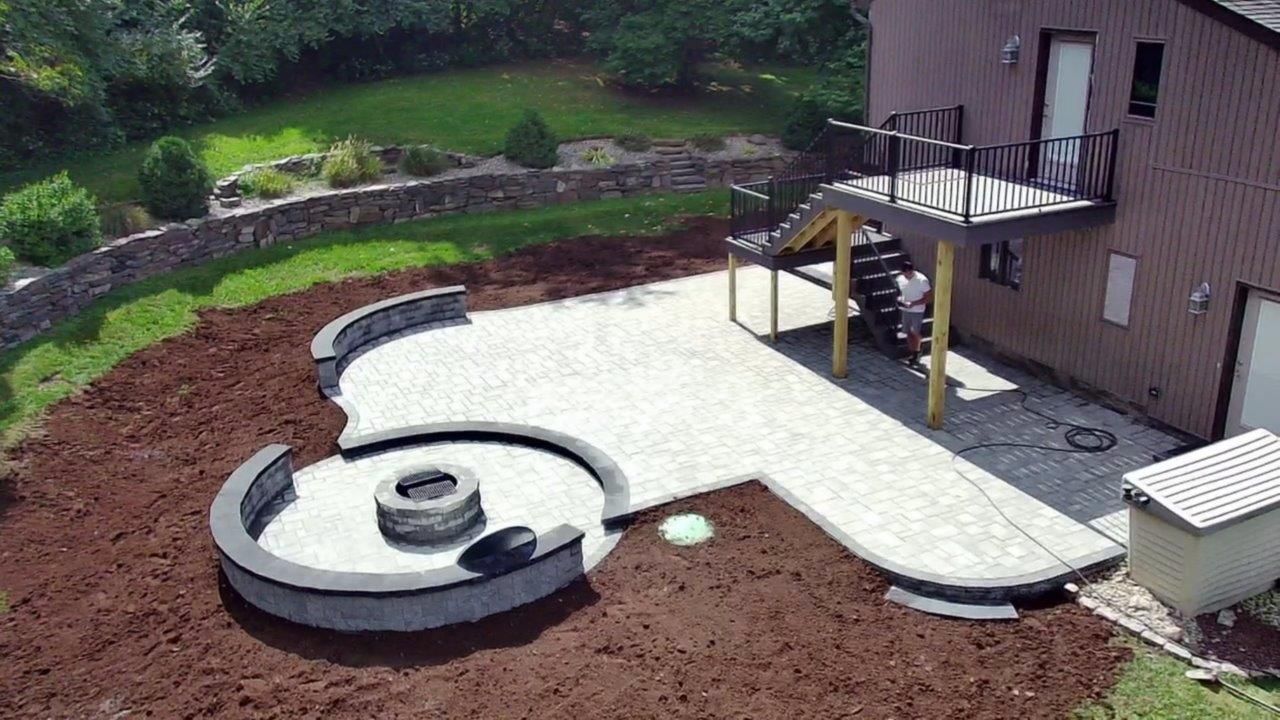 An aerial view of a patio with a fire pit in the middle of it.