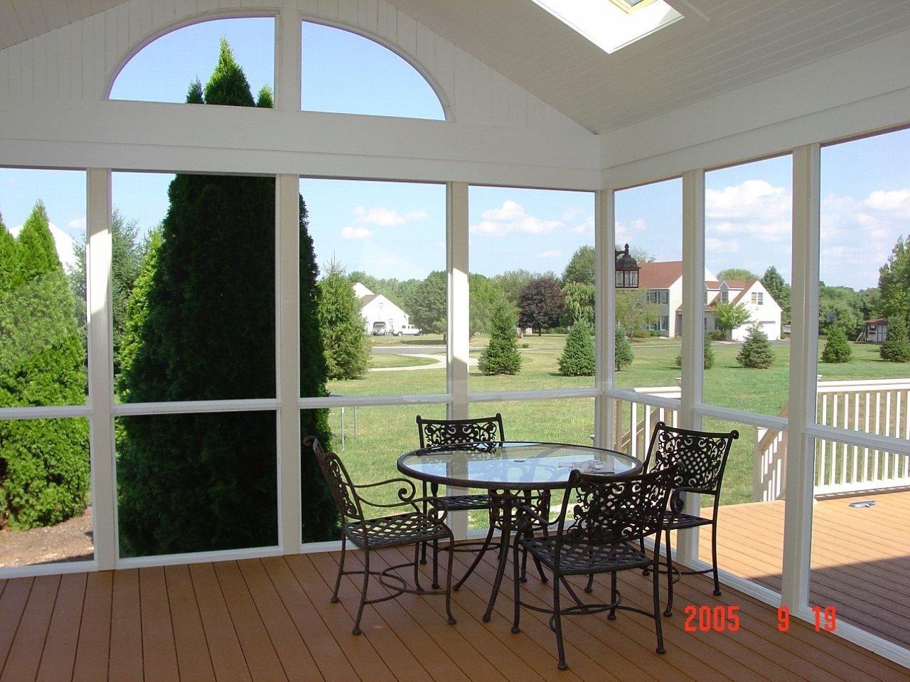 A screened in porch with a table and chairs in 2005