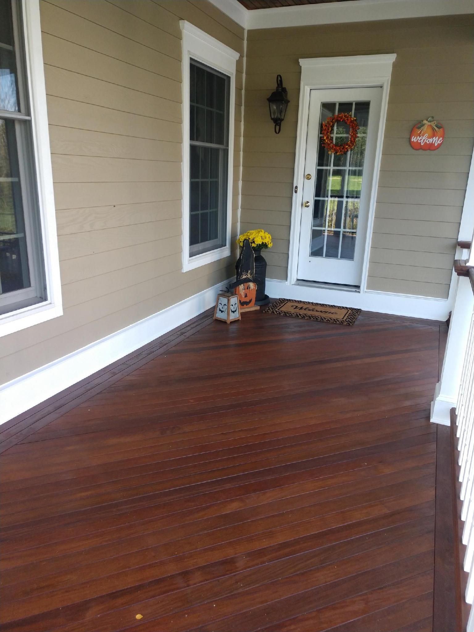 A porch decorated for halloween with a pumpkin and a wreath on it.