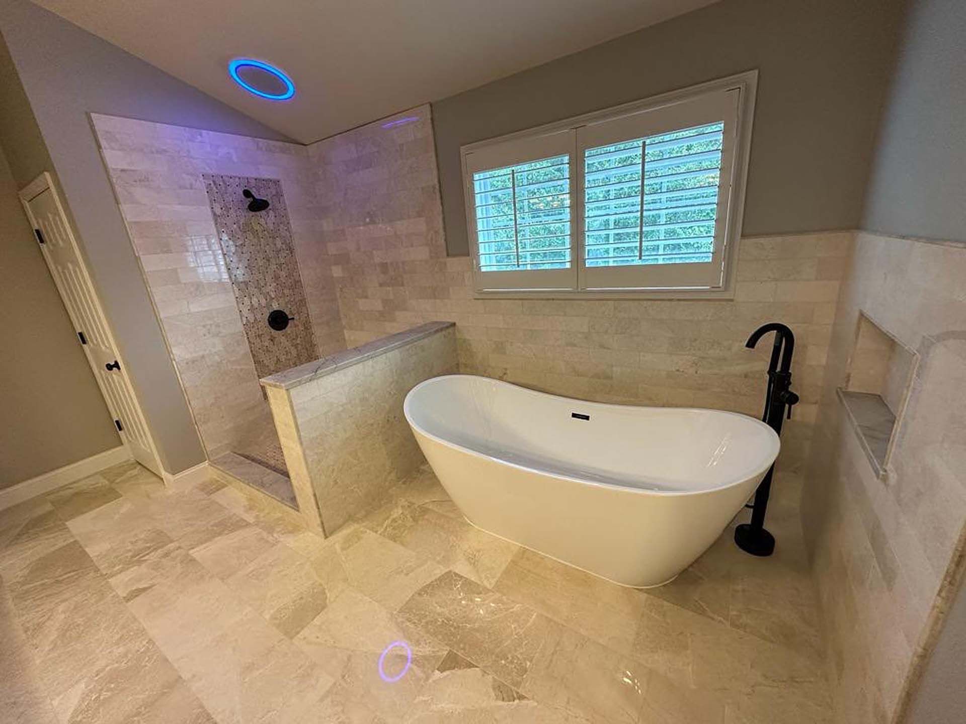 A bathroom with a bathtub , shower , and window.