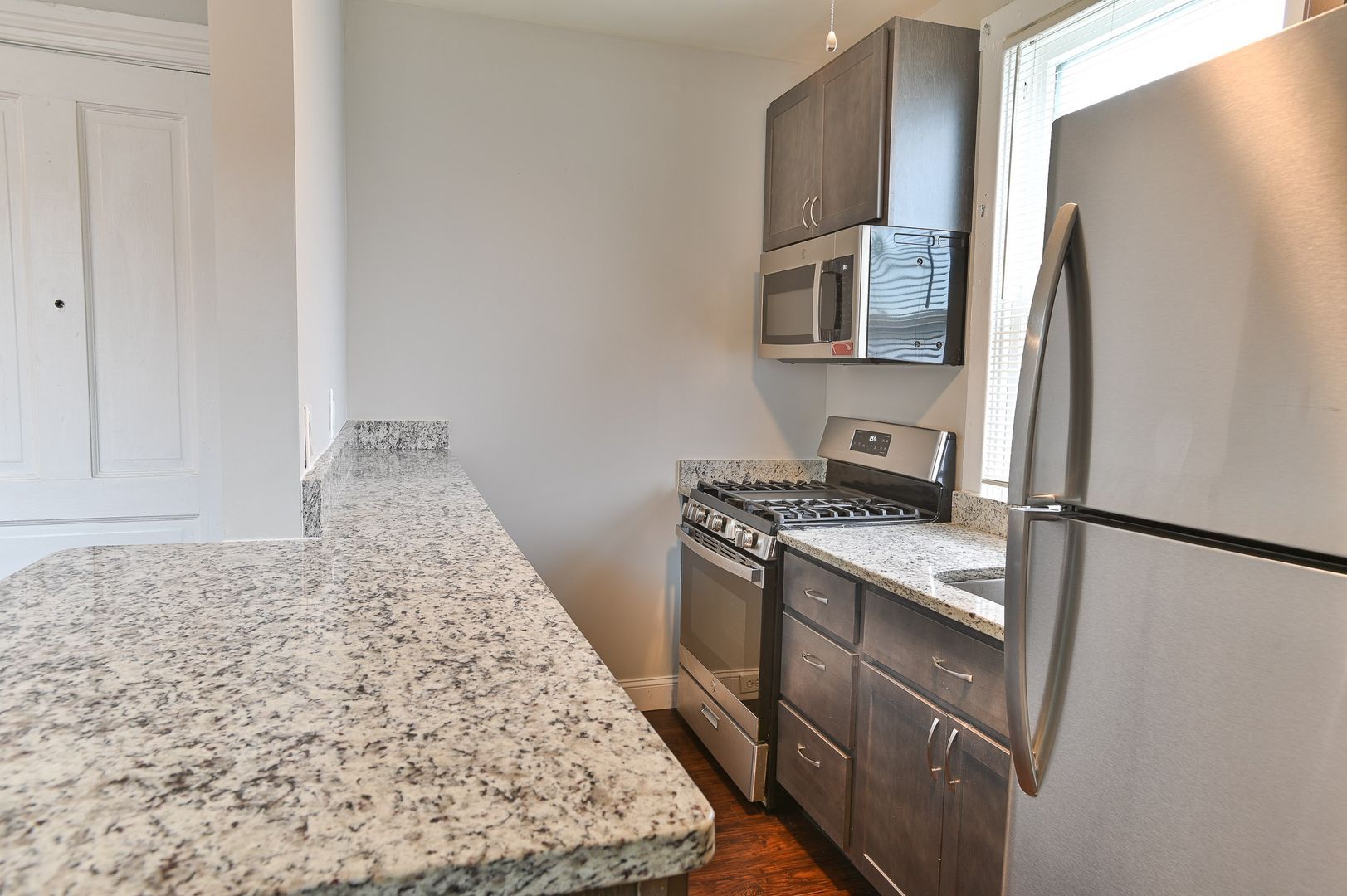 Kitchen with granite countertops, stainless steel appliances, and gray cabinets.