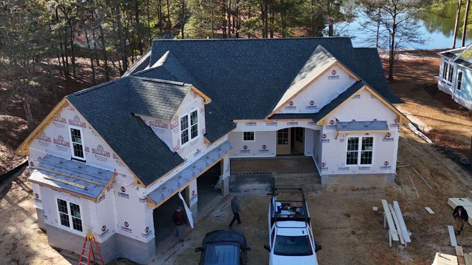 An aerial view of a house under construction with a truck parked in front of it.