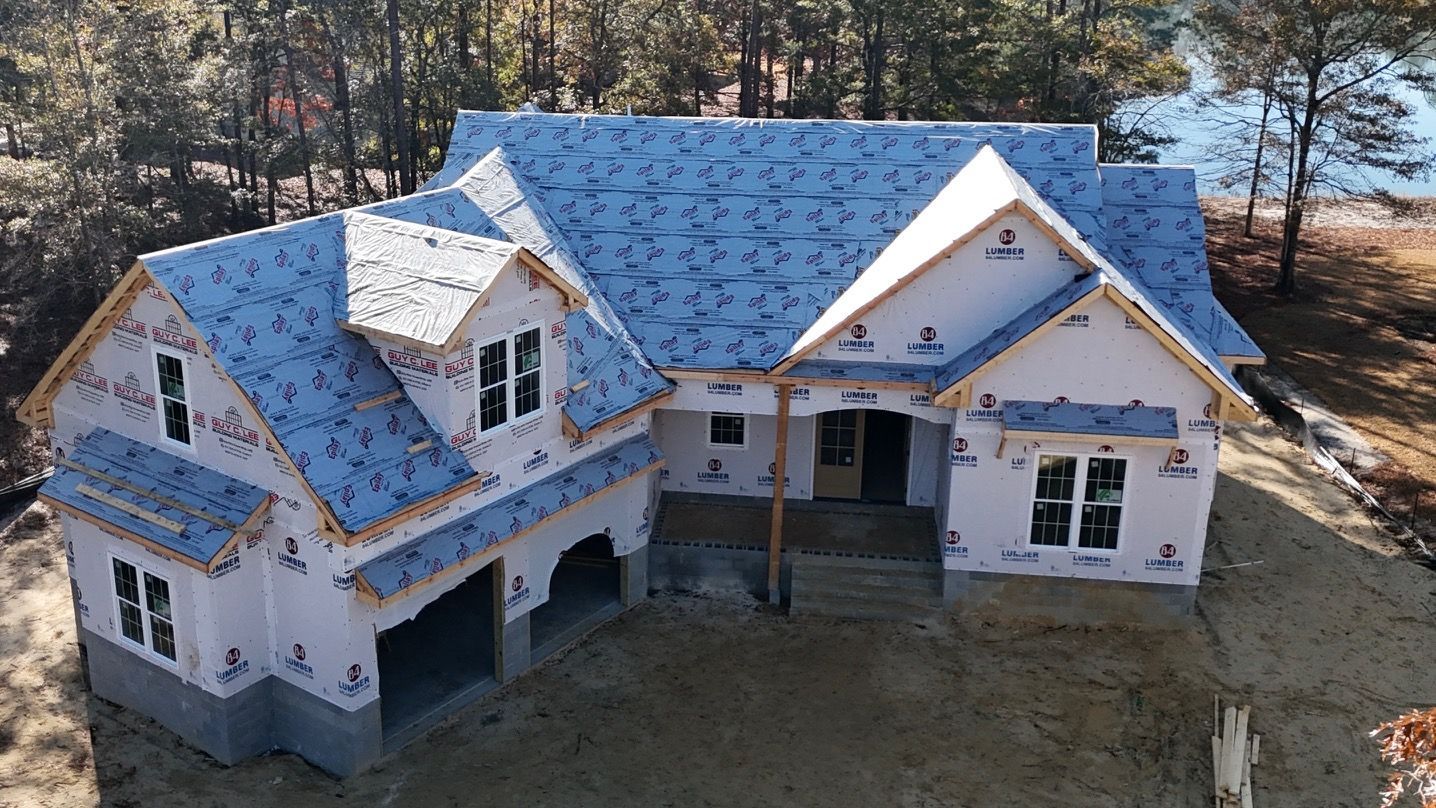 An aerial view of a house under construction with a blue roof.