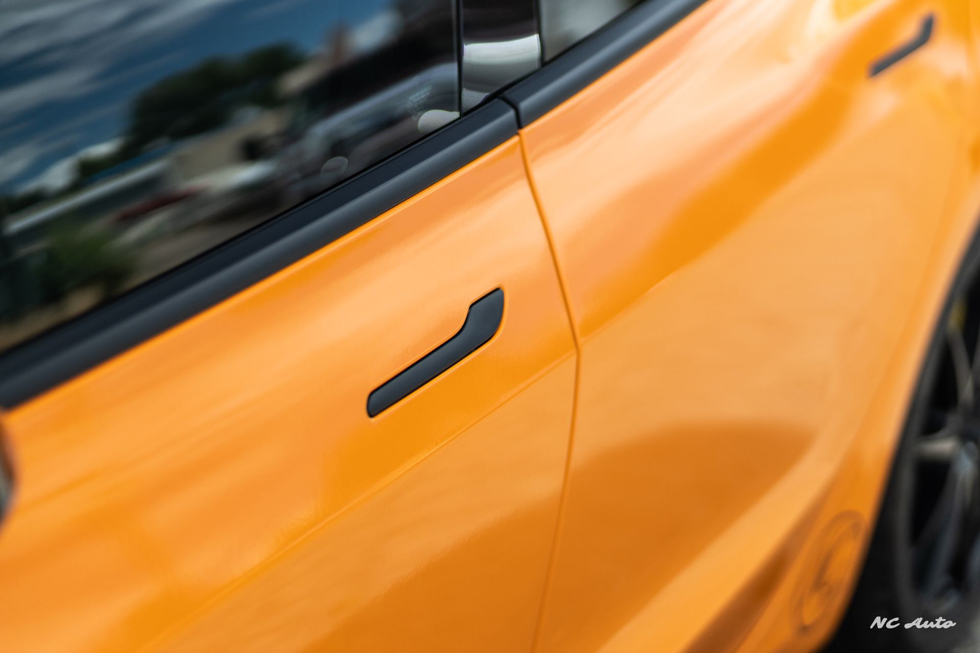 Orange car door with black handle.