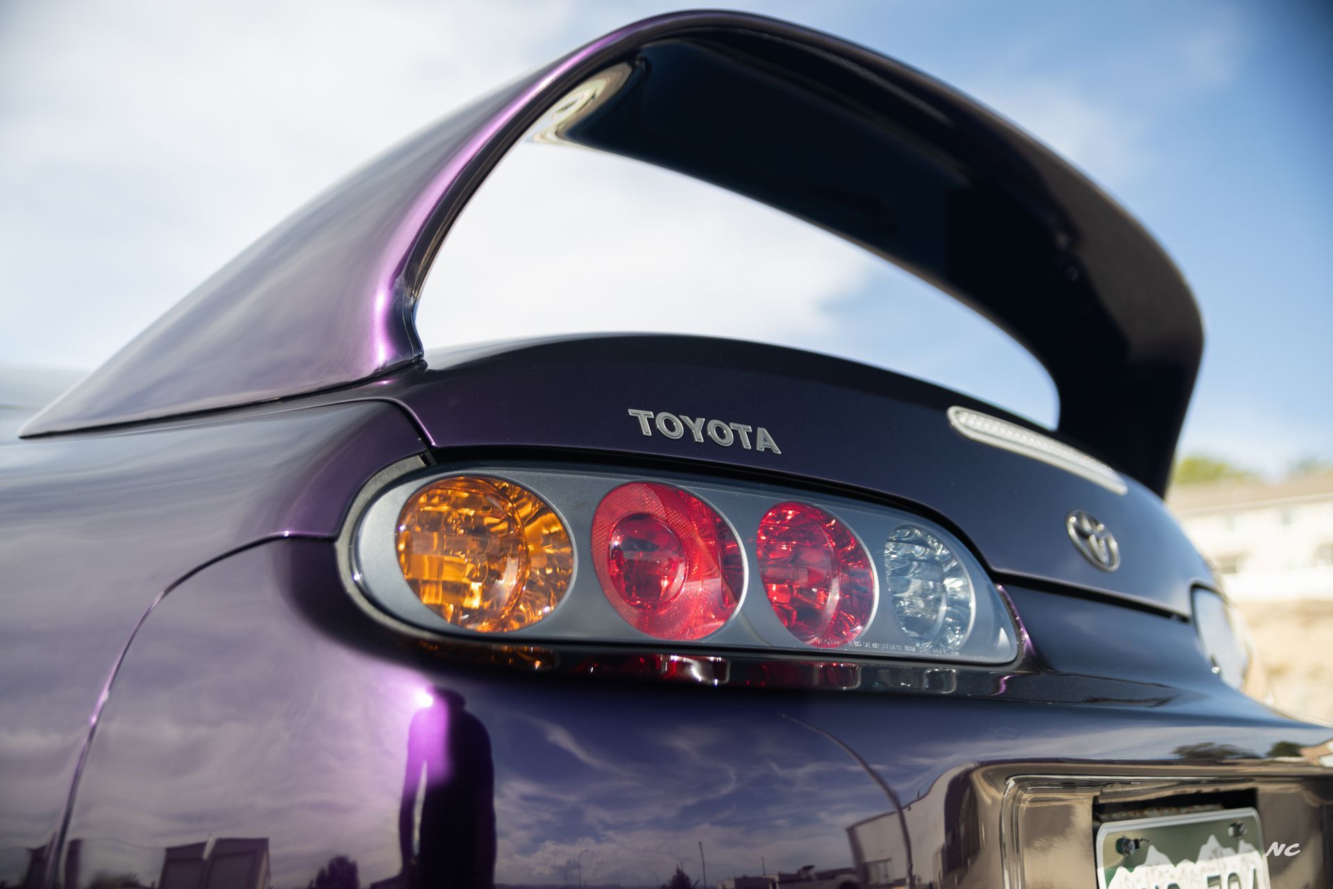 Purple Toyota Supra car tail lights and spoiler.