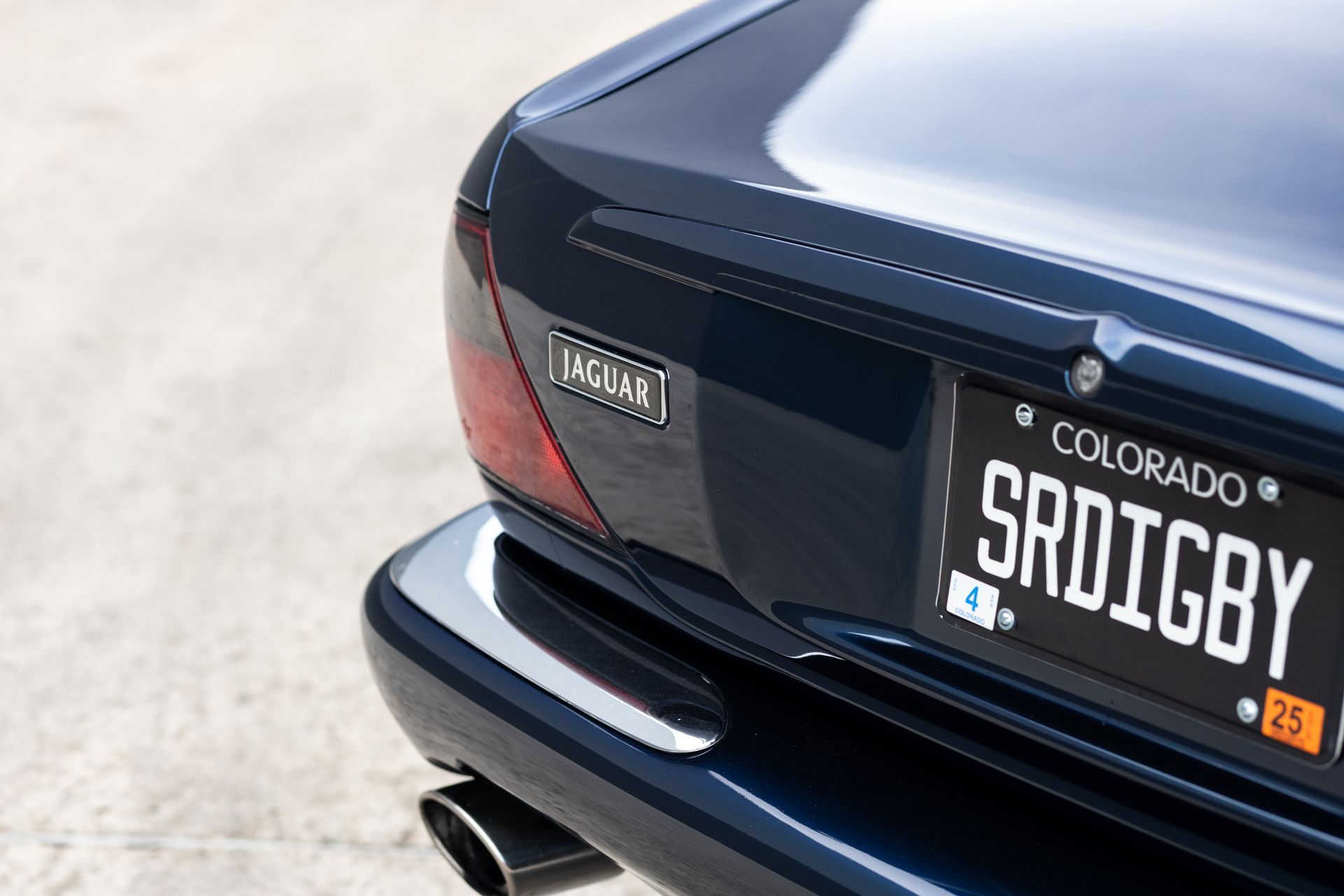 Close-up of a blue vintage car's rear, with a Colorado license plate reading 