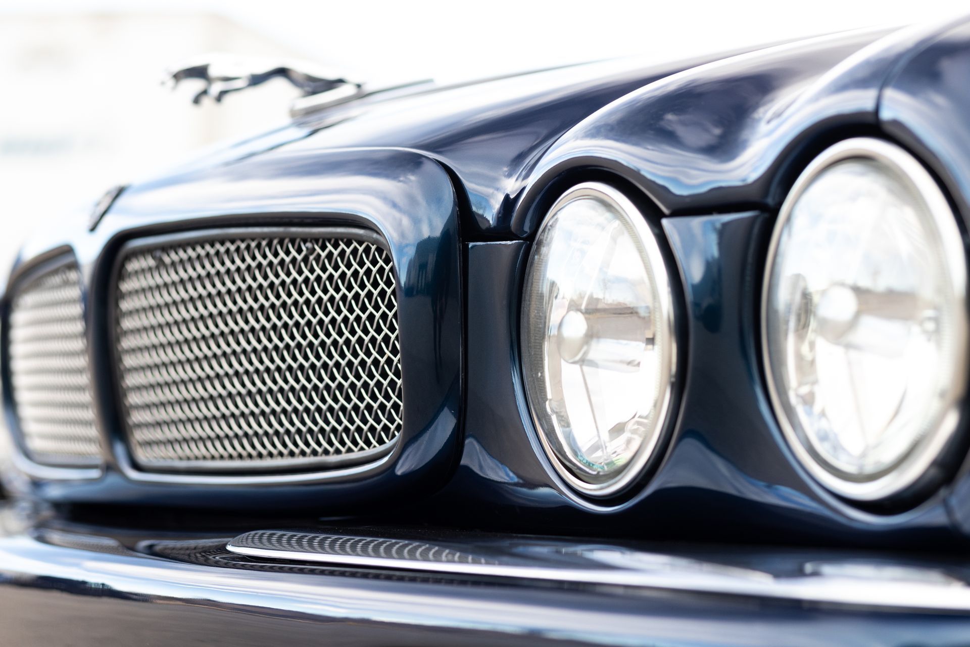 Blue classic car front: grill, headlights, and hood.