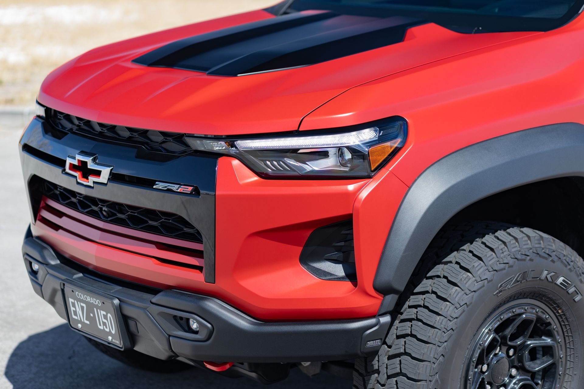 Red Chevrolet truck front. Black hood stripe, grille, and fender flares. 