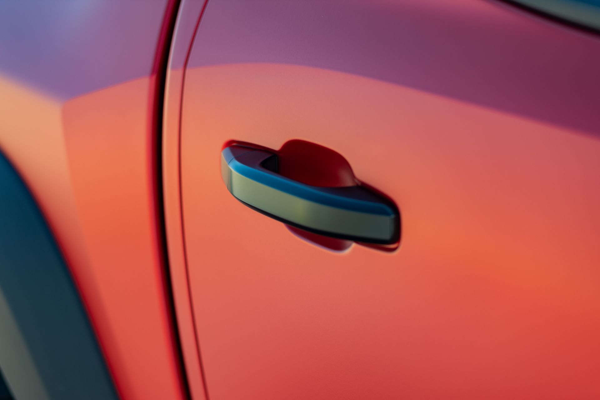 Red car door with a black and silver handle.
