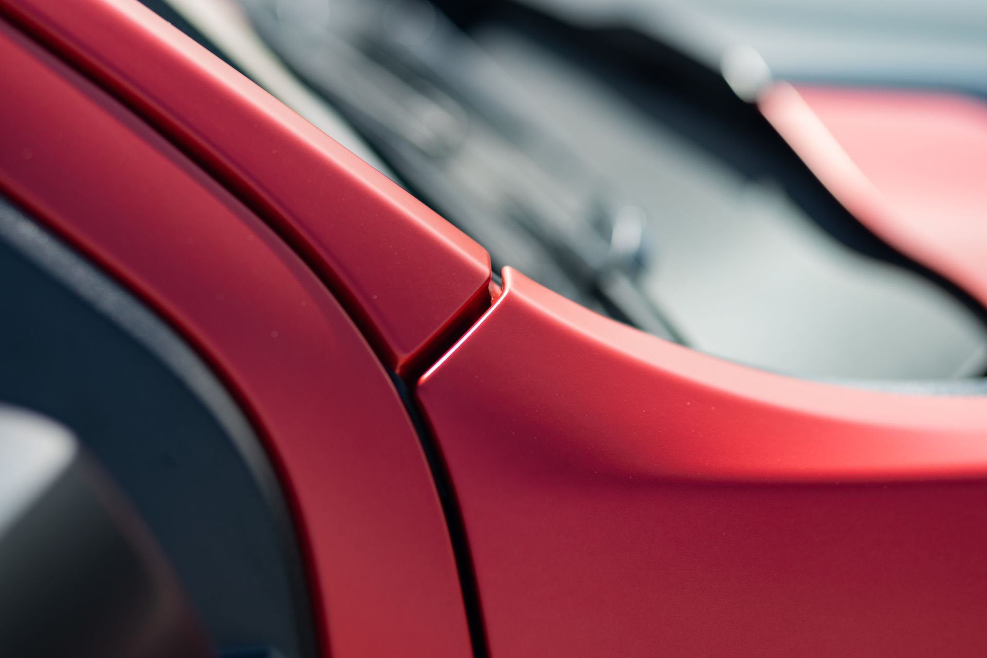 Red car door detail showing panel seams.
