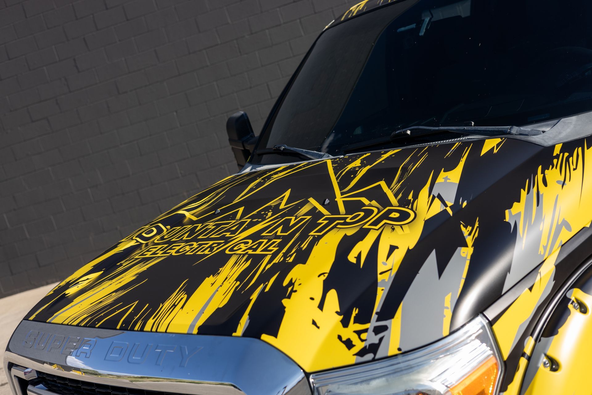 Yellow and black graphic wrap on a vehicle hood.