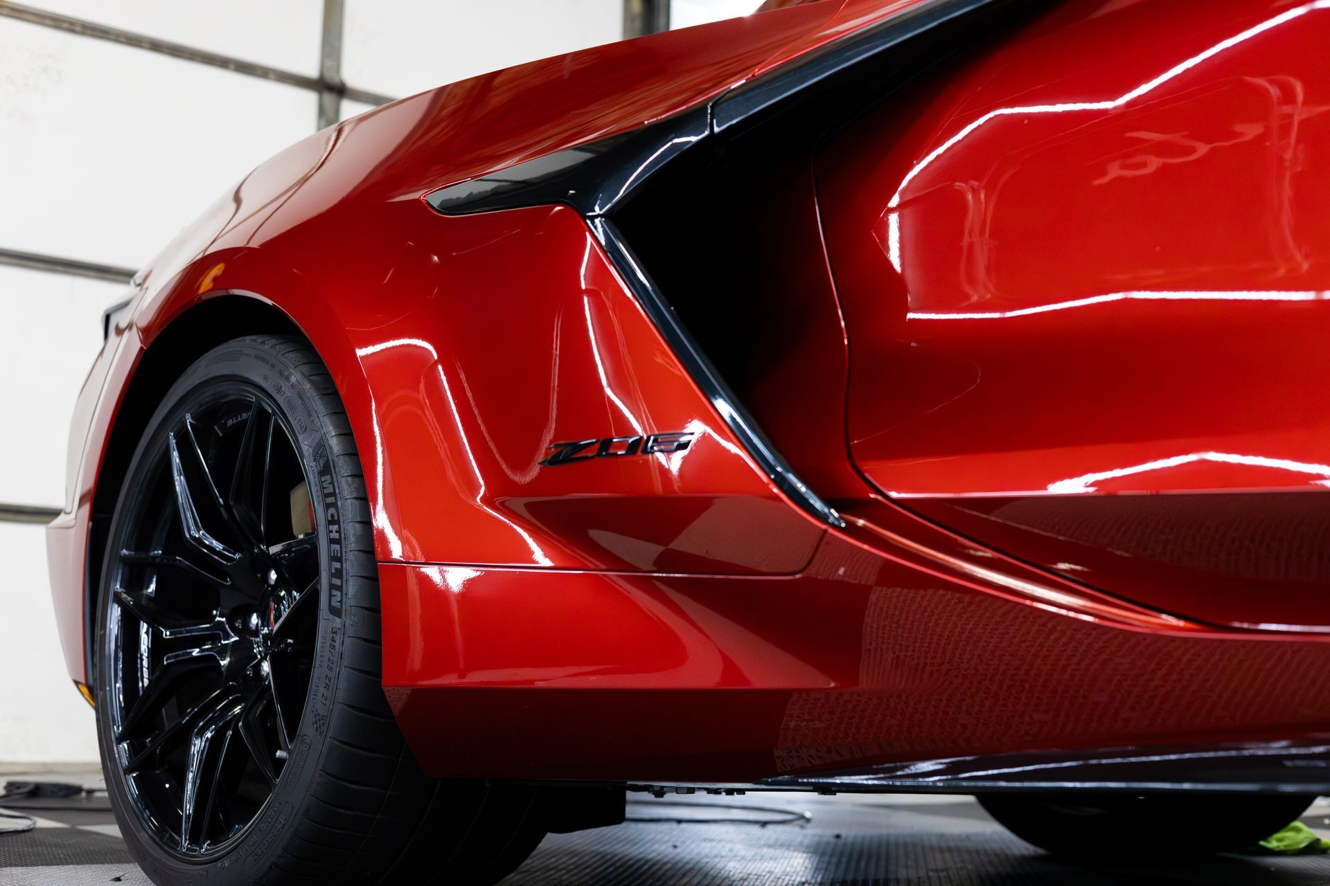 Red sports car's side with black wheel and 