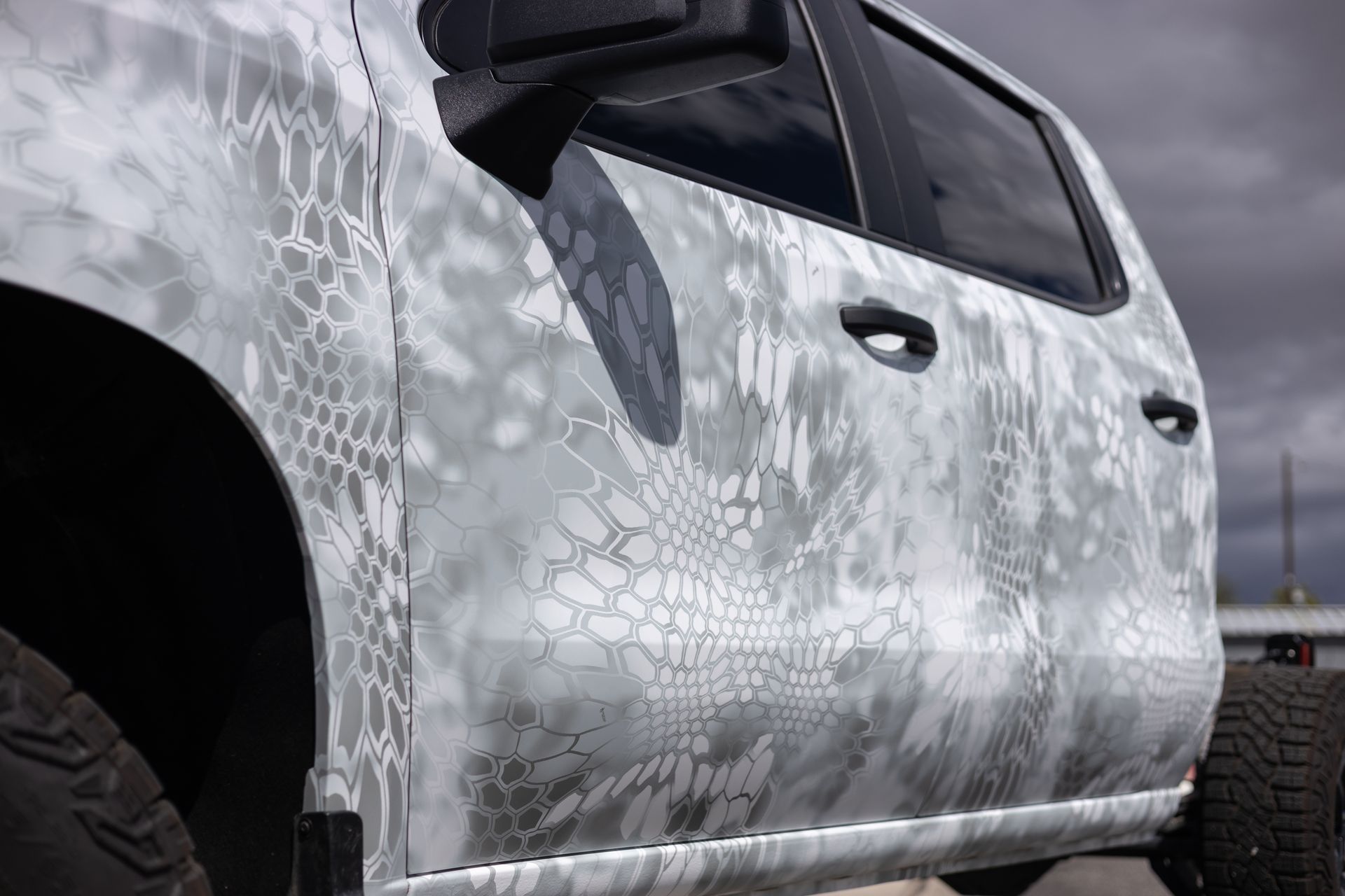 Truck side with grey and white camouflage pattern.