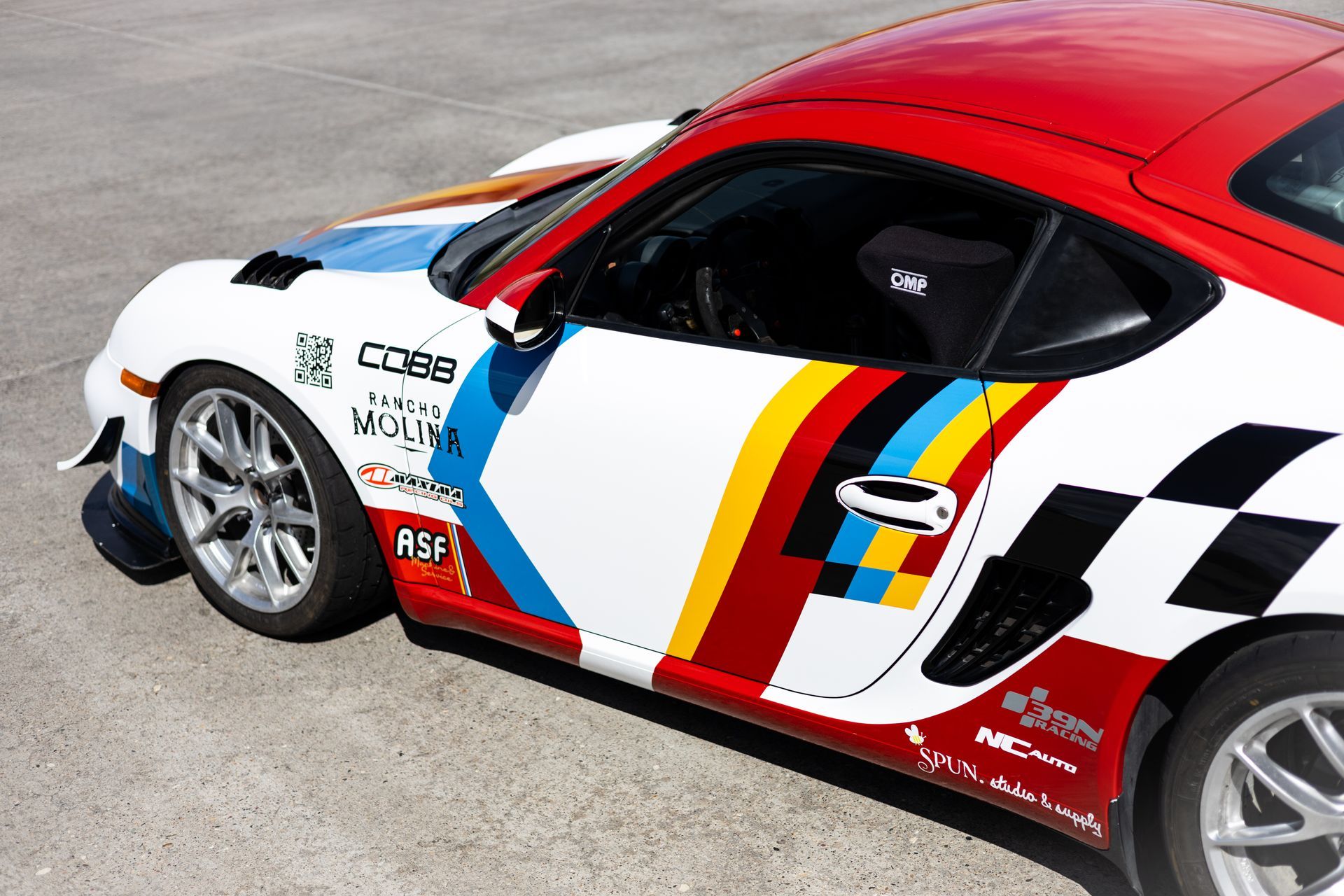 White, red, and blue race car with colorful stripes and checkered flag detail.