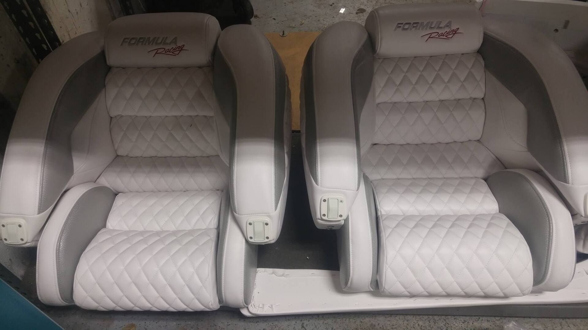 A pair of white and gray seats on a boat.