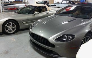 Two sports cars are parked next to each other in a garage.