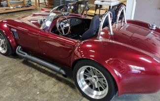 A red sports car is parked in a garage.
