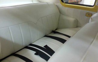 The back seat of a car is white with black stripes.