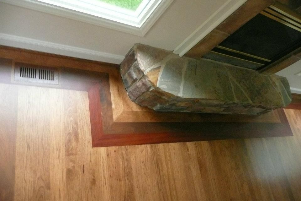 Wood floor with an angled stone hearth and vent.